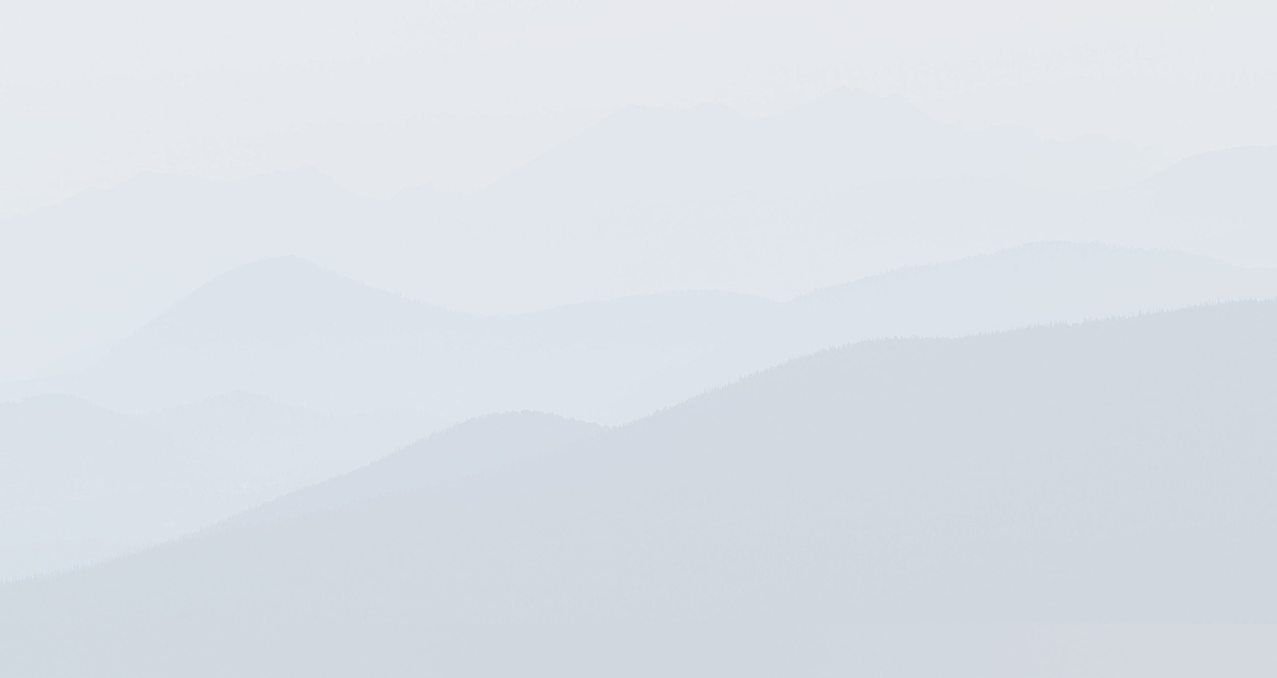 Foggy mountain landscape in soft pastel hues.