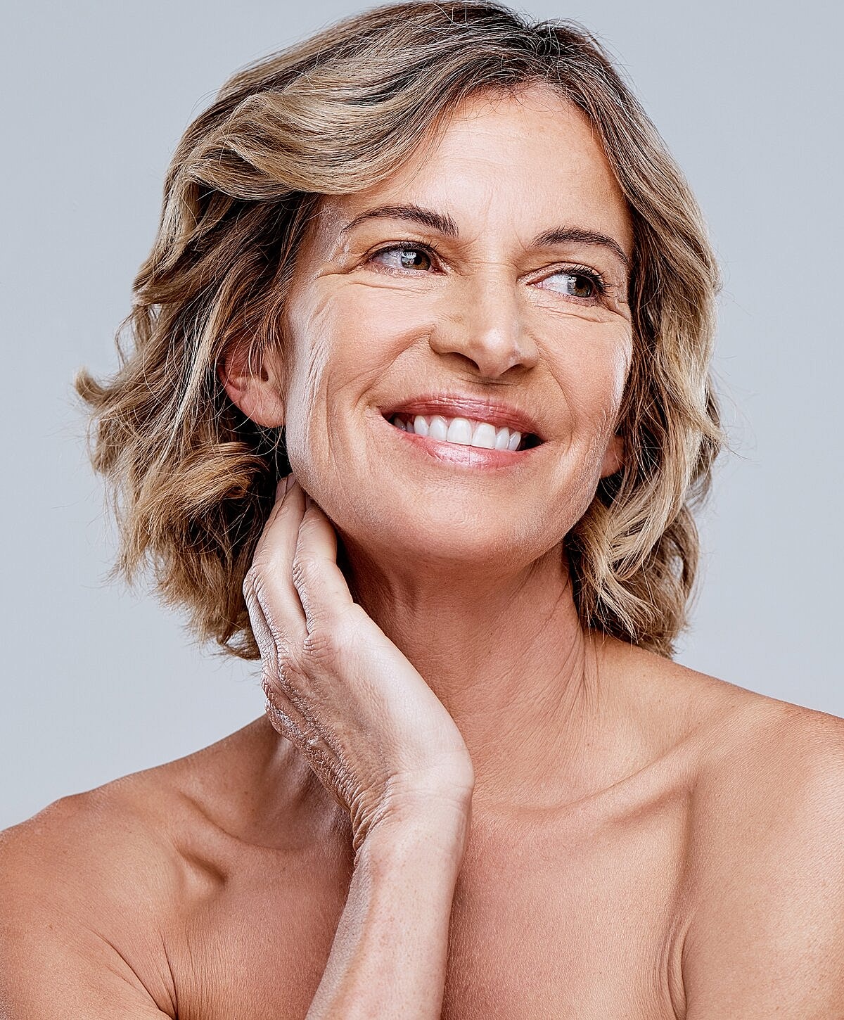 Smiling woman with long dark hair and necklace.