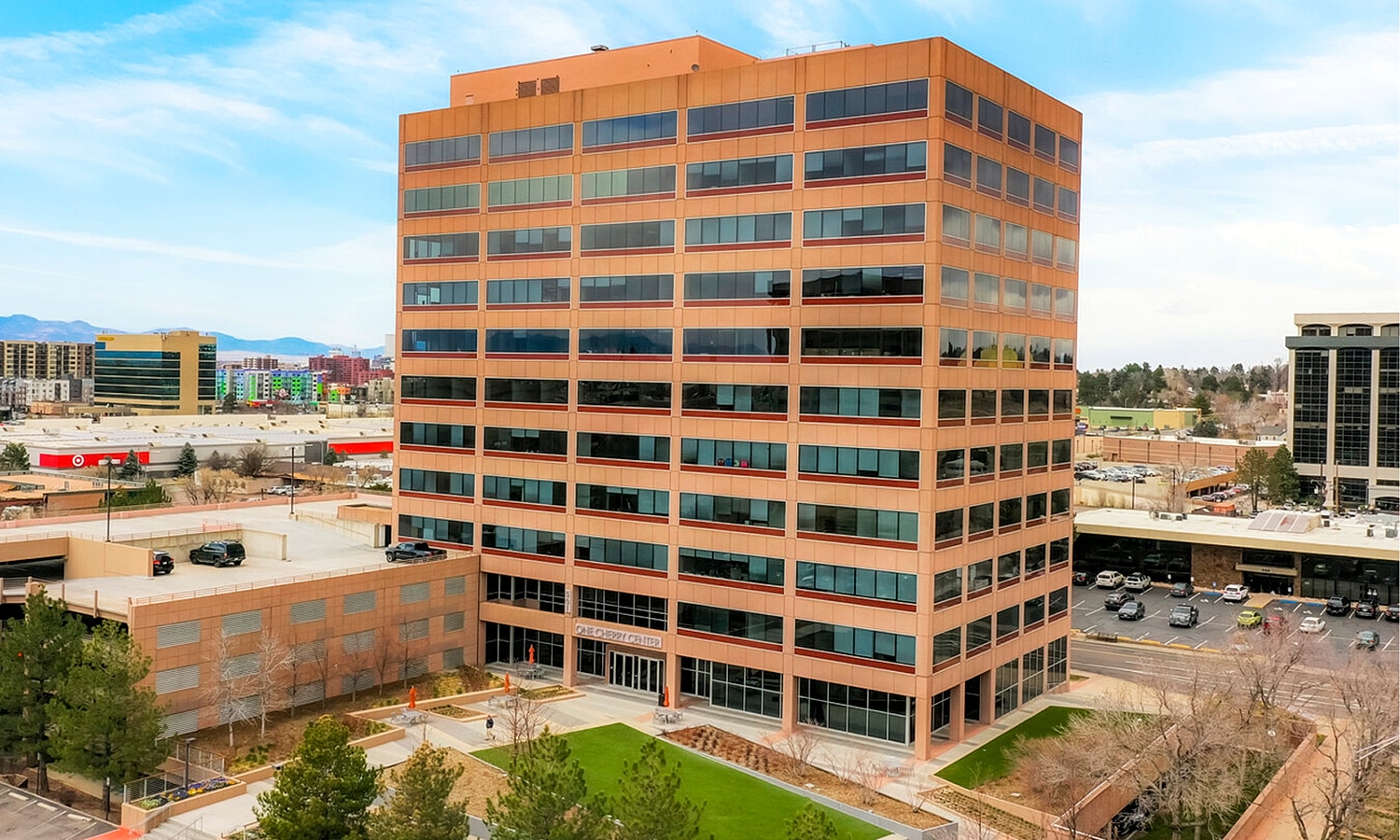 Smiling woman with curly hair and freckles.