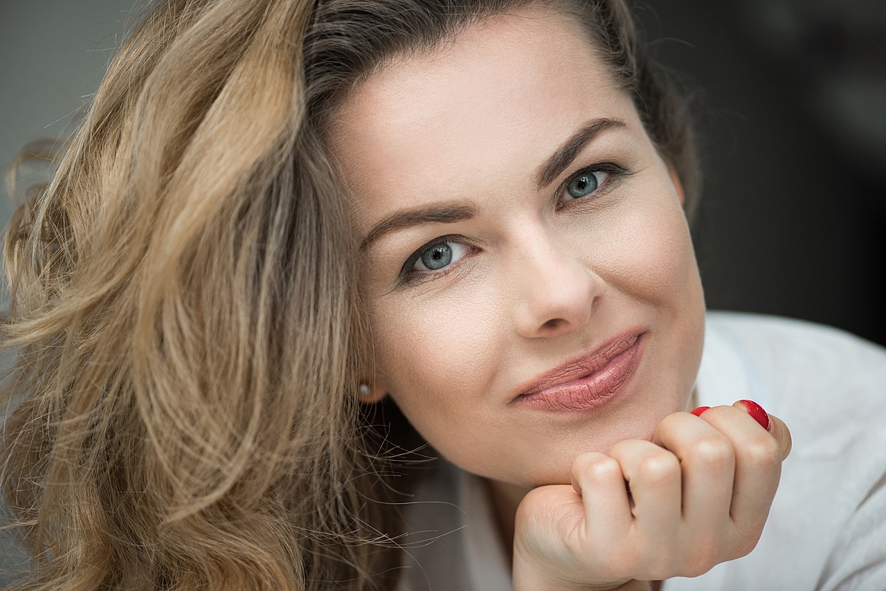 Denver Lip Filler model with long, wavy hair.