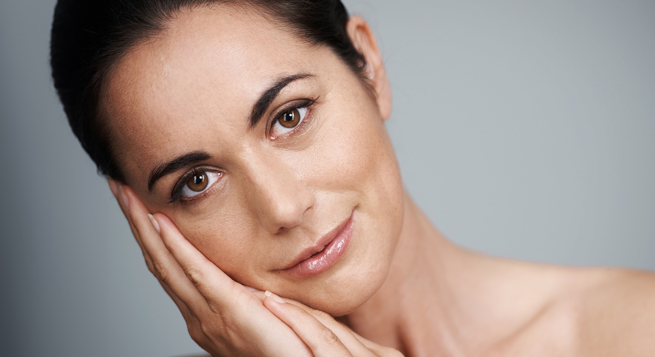 Woman gently resting her face on her hand.