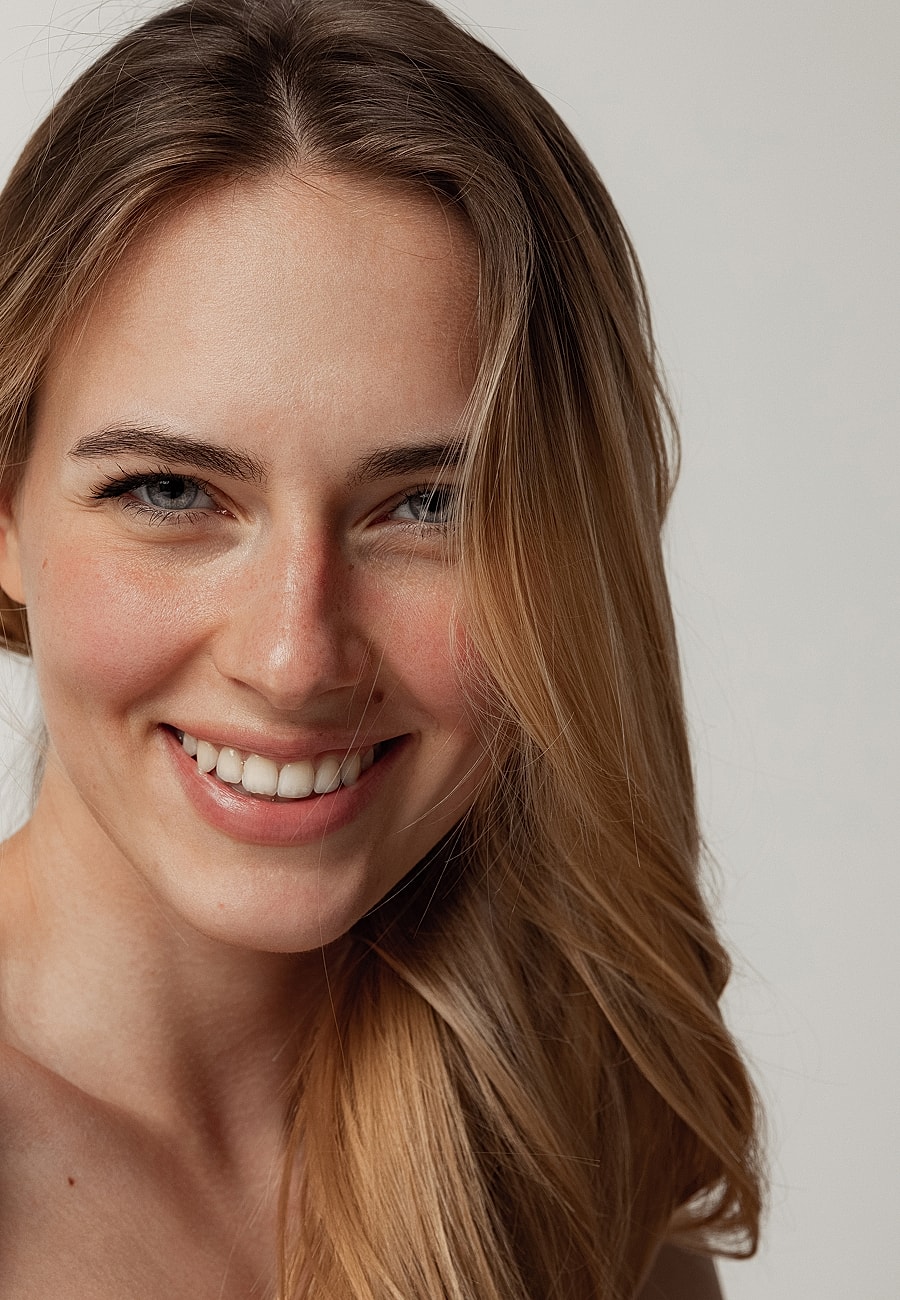 Smiling woman with long, wavy blonde hair.
